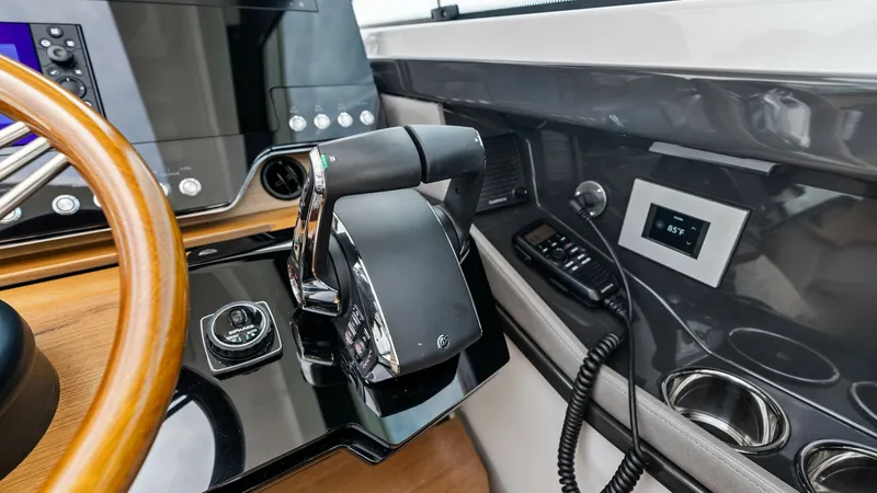 Slide: The Image of Helm Station with Controls The helm station of the Tiara 48LE showcases a modern and sleek design, featuring advanced navigation and control systems. The ergonomic throttle and joystick provide precise handling, while the large display screens offer easy access to essential data an - 7403635