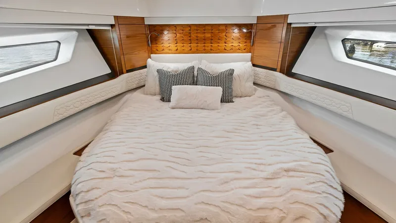 Slide: The Image of Luxurious Forward Stateroom The forward stateroom of the 2025 Tiara Yachts 48LE exudes comfort and elegance, featuring a plush queen-sized bed with premium bedding. Warm wood accents and chic upholstery create a sophisticated ambiance, while the large side windows offer ample natura - 7403591