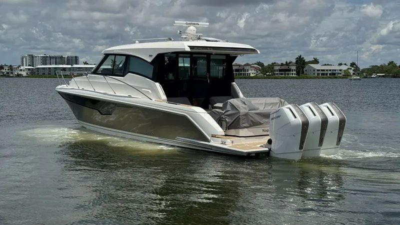 Slide: The Image of Sleek Aft Deck with Triple Engines The 2025 Tiara Yachts 48LE showcases a sleek aft deck featuring a spacious seating area covered for protection against the elements. The powerful triple outboard engines promise exceptional performance and speed, making this vessel perfect for both leisur - 7179512