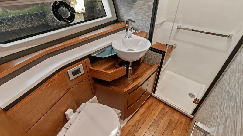 Slide: The Image of Luxurious Ensuite Bathroom This elegant ensuite bathroom aboard the 2025 Tiara Yachts 48LE offers a sophisticated blend of style and functionality. Featuring high-quality wood cabinetry and a sleek vessel sink, the space is both practical and aesthetically pleasing. The integrated - 7403649