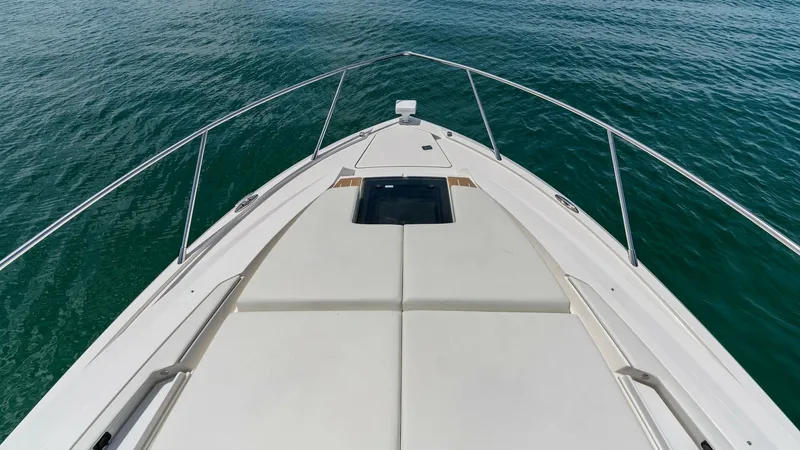 Slide: The Image of Spacious Forward Sunpad on Bow The Tiara Yachts 48LE features an expansive sunpad on the bow, perfect for lounging and enjoying the sea views. The sleek design is complemented by stainless steel railing and a built-in hatch for additional cabin light and ventilation. Ideal for relaxati - 7403619