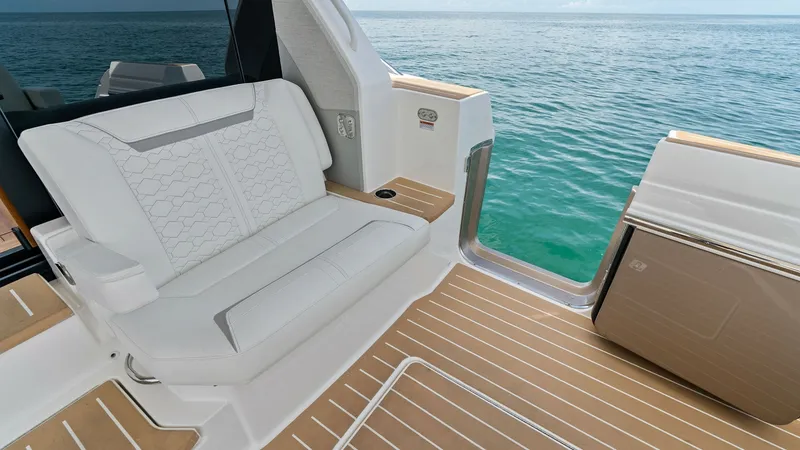 Slide: The Image of Aft Deck Seating Area This image showcases the elegant aft deck seating area of the 2025 Tiara Yachts 48LE. Featuring plush, weather-resistant upholstery, the seating provides comfort and style while overlooking the serene ocean. The teak flooring adds a touch of luxury, makin - 7403612