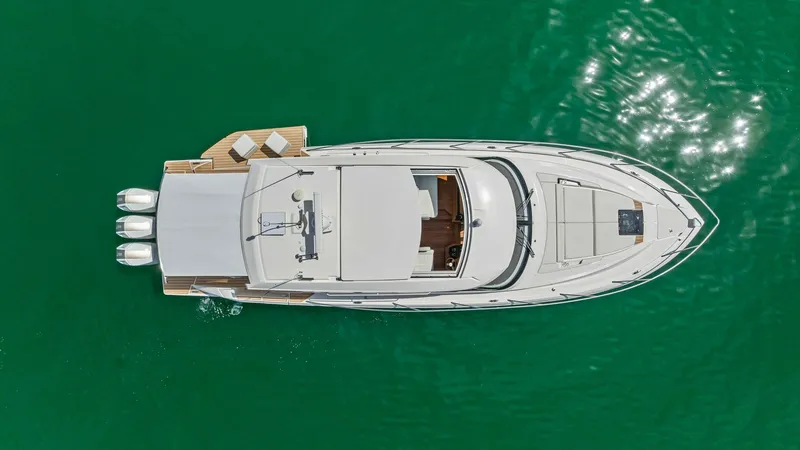 Slide: The Image of Aerial View of Deck Layout This aerial view showcases the sleek and modern design of the 2025 Tiara Yachts 48LE. The spacious aft deck features a sun lounge area, perfect for relaxation, while the helm station is centrally located for optimal visibility. The elegant lines and effic - 7403593