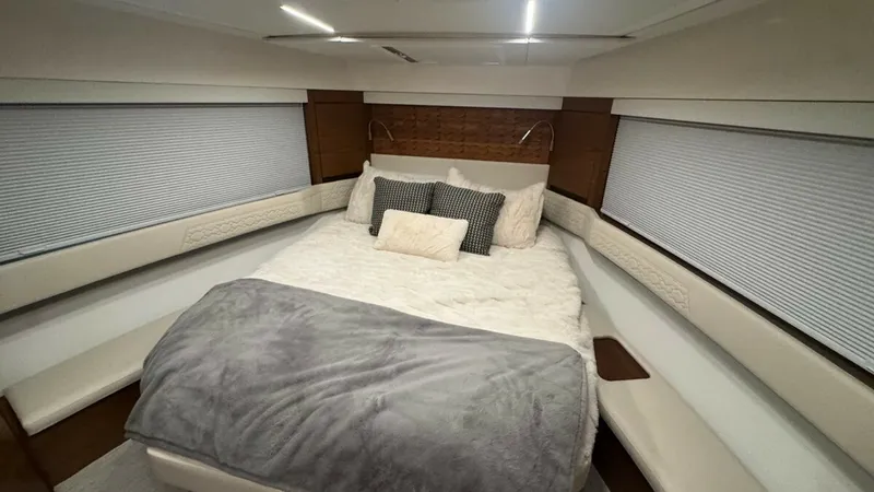 Slide: The Image of Luxurious Forward Stateroom The forward stateroom of the 2025 Tiara Yachts 48LE exudes comfort and elegance, featuring a plush queen-sized bed adorned with soft linens and accent pillows. The room is beautifully illuminated by recessed lighting, complemented by the warm tones of the - 7179507
