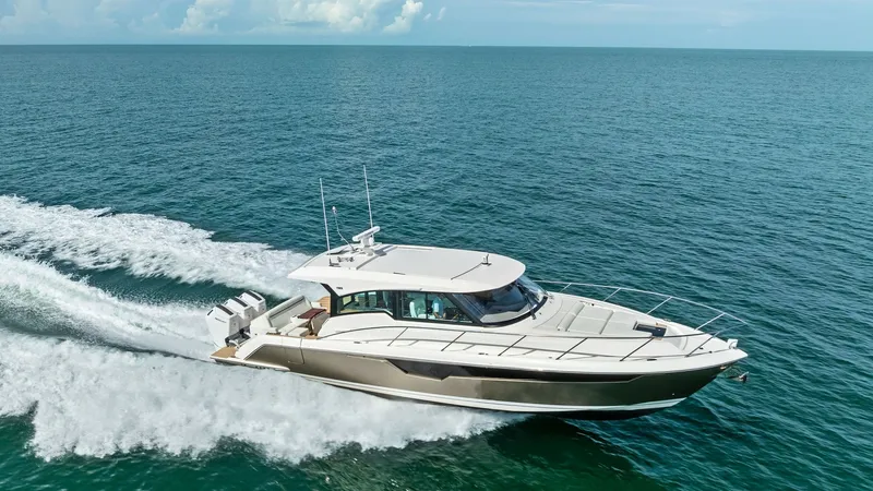 Slide: The Image of Aerial View of Tiara 48LE Cruising The 2025 Tiara Yachts 48LE cuts through the water with elegance, showcasing its sleek design and robust performance. This aerial view highlights the vessel's spacious deck, aerodynamic hardtop, and powerful triple outboard engines. The boat's striking pro - 7403668