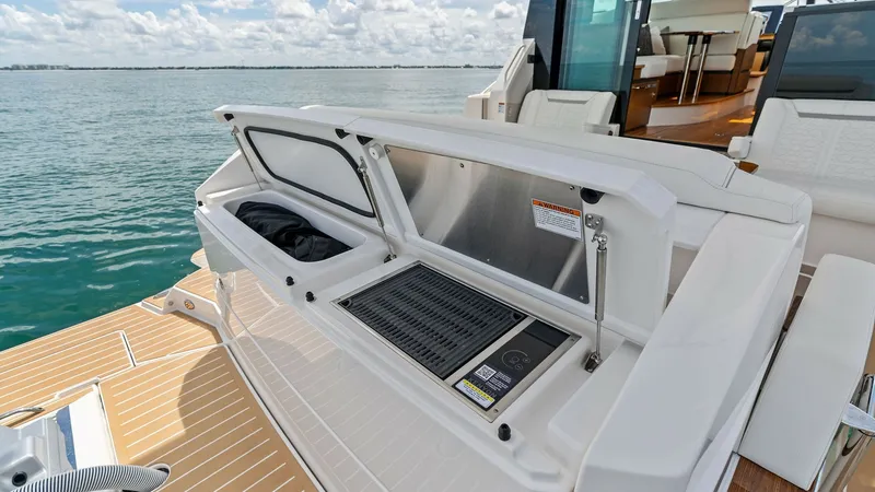 Slide: The Image of Stern Deck with Grill Station The stern deck of the 2025 Tiara Yachts 48LE features a sleek grill station, perfect for alfresco dining. The integrated grill is complemented by ample counter space and storage, offering convenience and style. The teak flooring and panoramic water views - 7403611