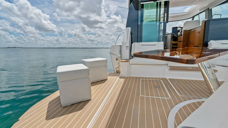 Slide: The Image of Spacious Aft Deck with Seating The aft deck of the Tiara Yachts 48LE offers a luxurious space for relaxation and socializing. Featuring elegant teak flooring and stylish white seating, it provides a perfect spot to enjoy the ocean views. The sleek design and ample seating make it ideal - 7403604