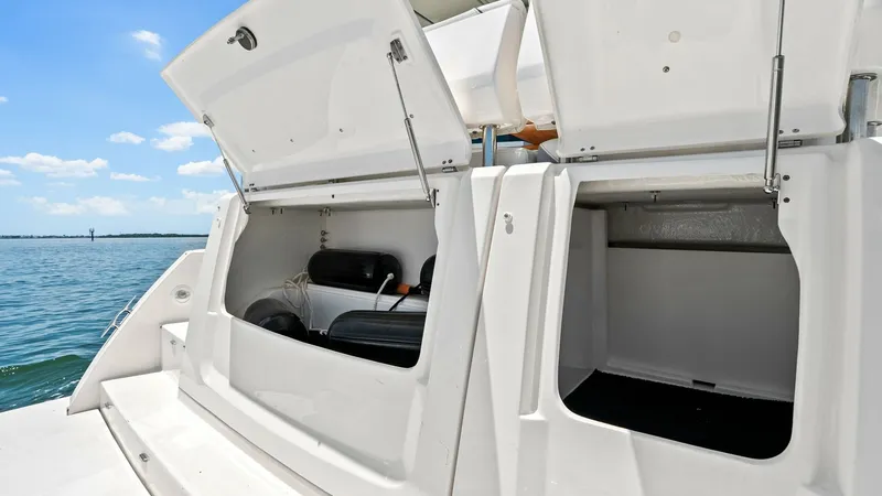 Slide: The Image of Transom Storage Compartments This image showcases the spacious transom storage compartments of the 2025 Regal 38 EXC. The compartments are designed for easy access and ample space, perfect for storing water sports equipment and essential gear. The sleek white finish complements the o - 7180454