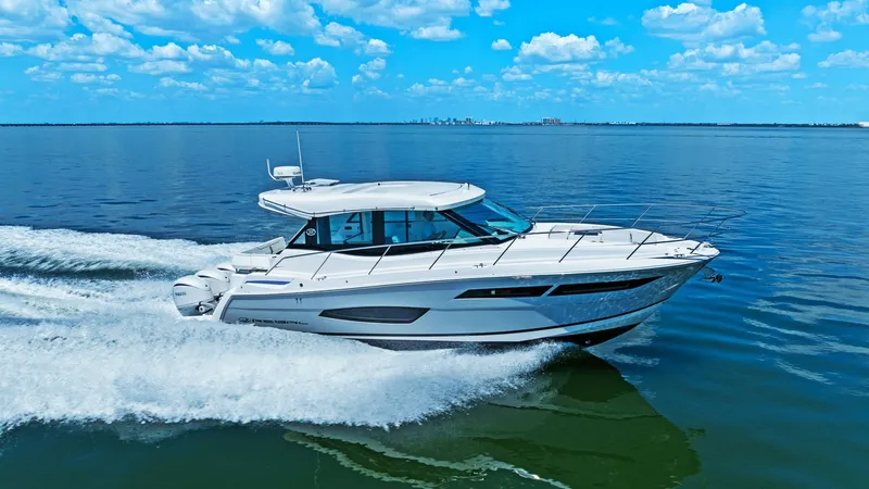 Slide: The Image of Starboard Profile Underway The 2025 Regal 38 EXC glides smoothly through the water, showcasing its sleek and aerodynamic design. The vessel's contemporary hull lines are complemented by a spacious cockpit and a streamlined hardtop. This dynamic profile highlights the yacht's perfor - 7180483