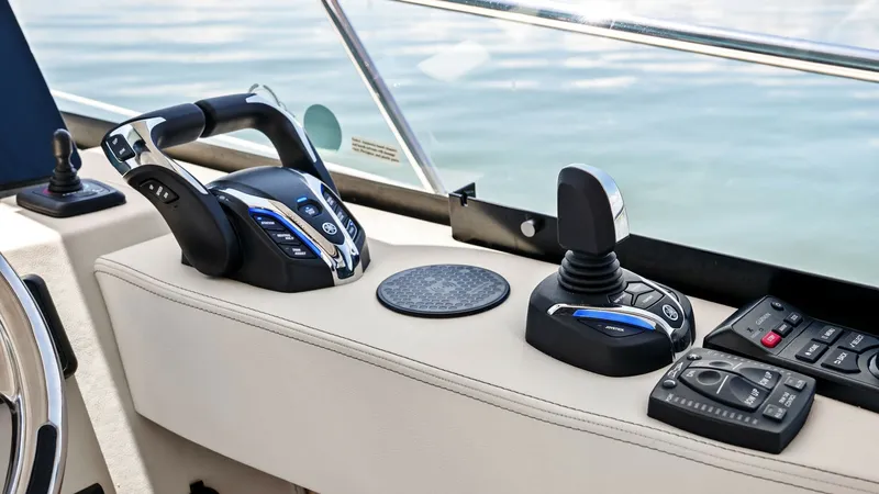 Slide: The Image of Helm Control Station with Joystick This image showcases the helm control station of the 2025 Regal 38 EXC. Featuring state-of-the-art dual throttle controls and an intuitive joystick for precise maneuverability, the setup ensures effortless navigation. The sleek design and premium material - 7180448