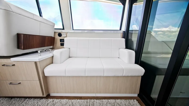 Slide: The Image of Main Salon Seating Area This inviting seating area in the main salon of the 2025 Regal 38 EXC features plush white upholstery that complements the light wood cabinetry. Large windows provide abundant natural light, enhancing the spacious feel and offering impressive views. The s - 7180433