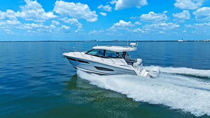 Slide: The Image of Regal 38 EXC Cruising at Sea The 2025 Regal 38 EXC is captured gliding effortlessly across open waters, showcasing its sleek, modern design. The vessel's aerodynamic profile and powerful outboard engines ensure a smooth, efficient ride, perfect for both leisurely cruises and exhilara - 7180476