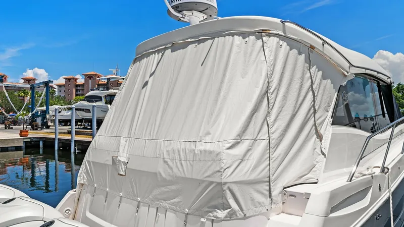 Slide: The Image of Aft Deck with Protective Cover The aft deck of the 2025 Regal 38 EXC features a protective cover, ensuring the area is shielded from the elements. This space is equipped with a sturdy railing and easy access to the water, enhancing both safety and convenience. The vessel's sleek lines - 7180465