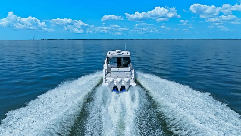 Slide: The Image of Aft View Cruising at Speed The Regal 38 EXC cuts through the water with powerful outboard engines, leaving a dynamic wake in its path. This aft view showcases the vessel's sleek design and robust performance, perfect for those seeking thrilling open water adventures. The expansive - 7180475