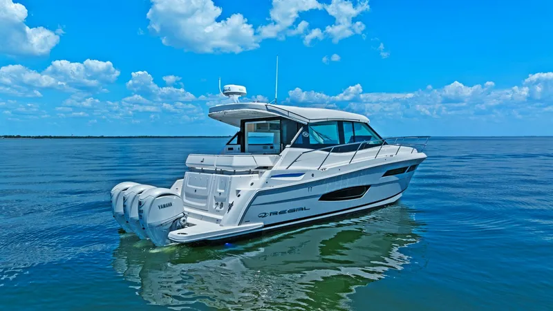 Slide: The Image of Aft View with Triple Outboards This image showcases the sleek aft view of the 2025 Regal 38 EXC from Galati Yacht Sales. The vessel features triple Yamaha outboard engines, providing powerful performance and smooth cruising. The spacious swim platform and elegant lines highlight the ya - 7180468