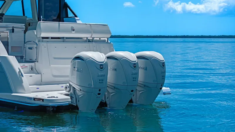 Slide: The Image of Triple Outboard Engines on Aft Deck This image showcases the powerful triple outboard engines of the 2025 Regal 38 EXC, designed for optimal performance and efficiency. The sleek aft deck provides easy access to the water, enhancing the vessel's appeal for both cruising and water sports. Wi - 7180474
