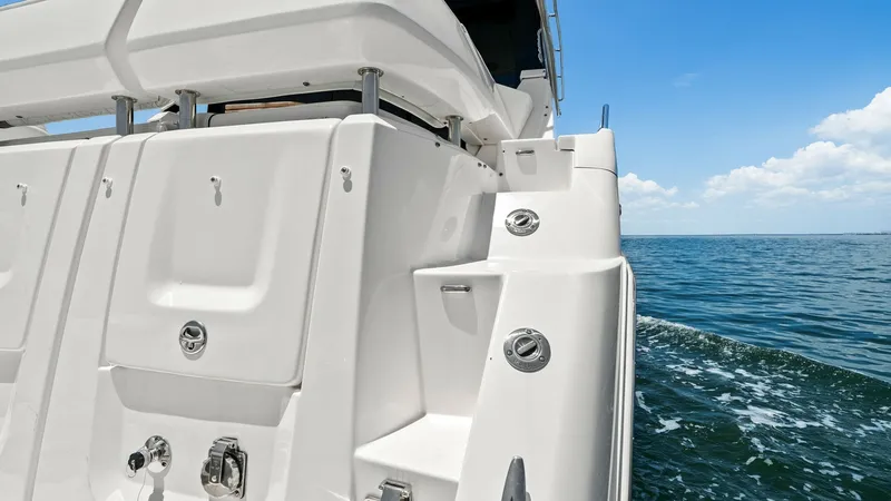 Slide: The Image of Stern View with Swim Platform The 2025 Regal 38 EXC features a sleek and functional stern design with an integrated swim platform. This area is equipped with secure access steps and polished stainless steel fixtures, ideal for water activities or relaxation. The clean lines and white - 7180453