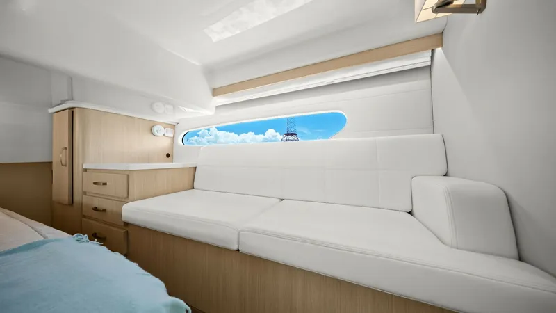 Slide: The Image of Elegant Interior Lounge with View The interior lounge of the 2025 Regal 38 EXC showcases a modern design with its sleek white upholstery and light wood cabinetry, creating a bright and inviting space. A large window offers picturesque views, enhancing the sense of openness and connection - 7180446