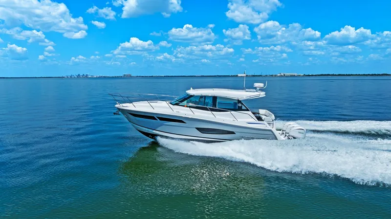 Slide: The Image of Regal 38 EXC Cruising Profile The 2025 Regal 38 EXC cuts a sleek figure as it cruises effortlessly across open waters. The streamlined hull and contemporary design highlight the vessel's performance capabilities and aesthetic appeal. With a spacious deck and powerful outboard engines, - 7180477