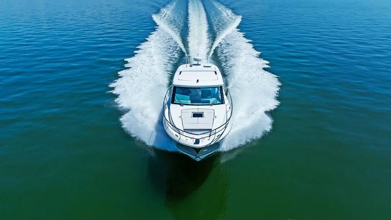 Slide: The Image of Aerial View of Bow Underway The 2025 Regal 38 EXC cuts through the water with elegance and power, showcasing its sleek bow design. The vessel's pristine white hull contrasts beautifully with the deep blue sea, emphasizing its dynamic performance. This aerial perspective highlights t - 7180480