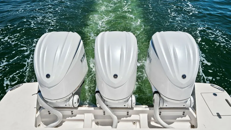 Slide: The Image of Triple Outboard Engines View This image showcases the powerful triple outboard engines of the 2025 Regal 38 EXC, designed for superior performance and reliability. The sleek, modern engine cowls emphasize the vessel's cutting-edge engineering and capability for high-speed cruising. T - 7180452