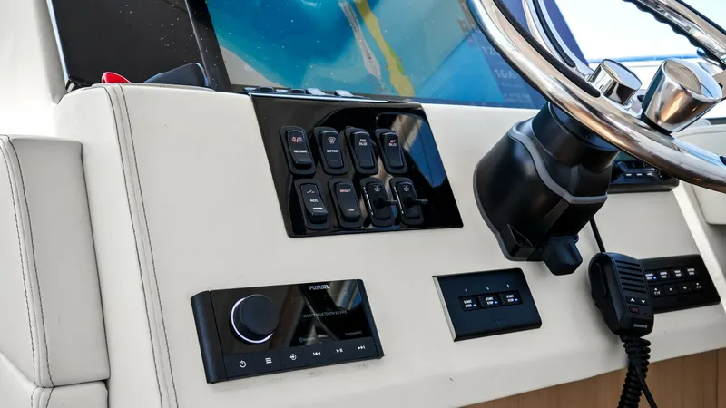 Slide: The Image of Helm Station with Modern Controls The helm station of the 2025 Regal 38 EXC showcases a sleek, modern design featuring advanced electronic controls and a multifunctional display. The ergonomic layout ensures ease of navigation with intuitive access to the vessel's systems. High-quality ma - 7180450