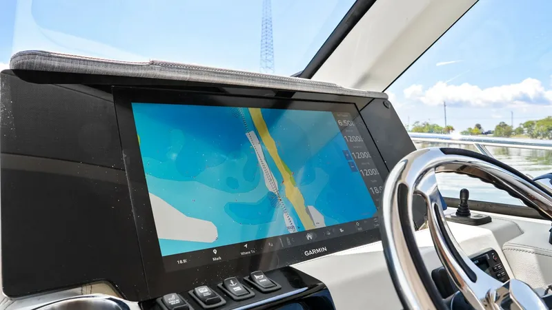 Slide: The Image of Helm Station with Navigation Display The helm station of the 2025 Regal 38 EXC features a modern navigation display, providing clear and precise mapping for smooth sailing. The sleek design includes a polished steering wheel and accessible control buttons, ensuring effortless maneuverability - 7180449