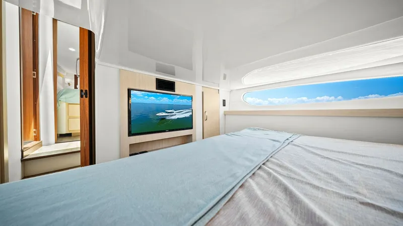 Slide: The Image of Luxurious Stateroom with Ocean View This elegant stateroom on the 2025 Regal 38 EXC features a plush bed with premium linens and a large window offering breathtaking ocean views. Modern entertainment is provided by a sleek, built-in flat-screen TV, perfectly positioned for comfort. The room - 7180445