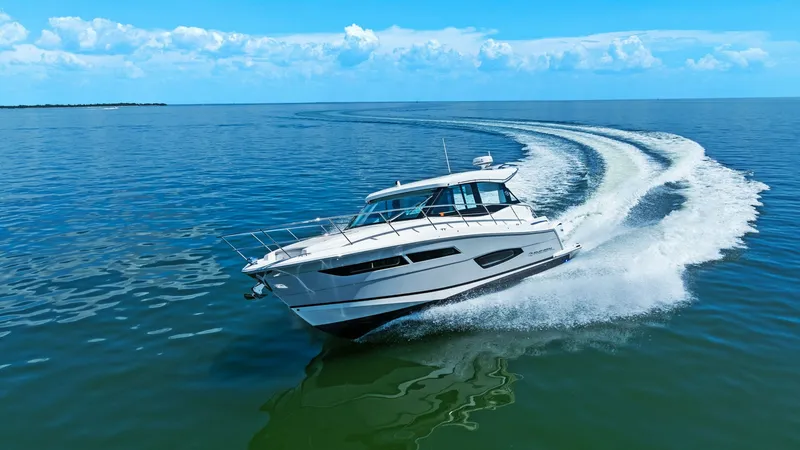 Slide: The Image of Dynamic Bow View in Motion This striking image showcases the Regal 38 EXC cutting through the water with precision and elegance. The sleek hull design and aerodynamic lines emphasize its modern aesthetic, while the expansive windows promise panoramic views from within. The vessel's - 7180485