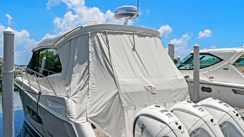 Slide: The Image of Aft Deck with Engine View This image showcases the aft deck of the 2025 Regal 38 EXC, featuring a protective canvas cover. Visible are the powerful dual outboard engines, ensuring superior performance and efficiency. The deck's design provides easy access and maintenance, making i - 7180466