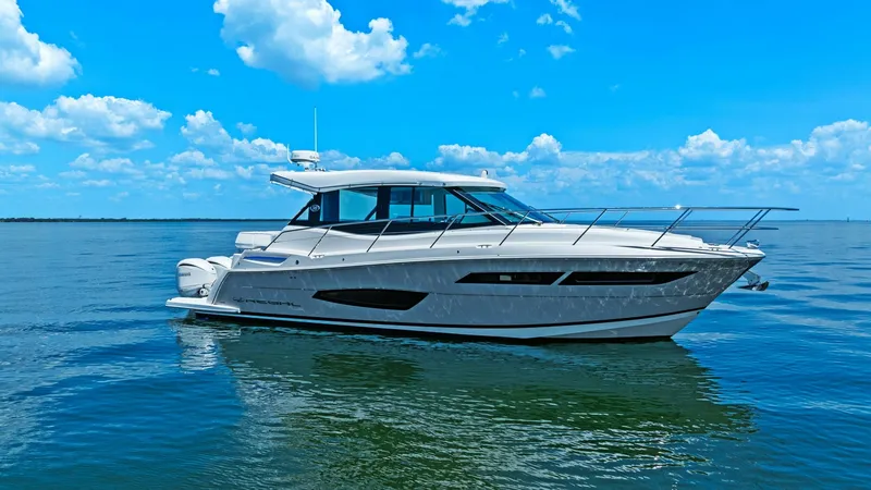Slide: The Image of Starboard Profile of Regal 38 EXC The 2025 Regal 38 EXC is elegantly showcased with a sleek starboard profile against the serene backdrop of open water. Its modern design features expansive windows and a streamlined hull, providing both style and performance. The vessel's polished exterio - 7180467