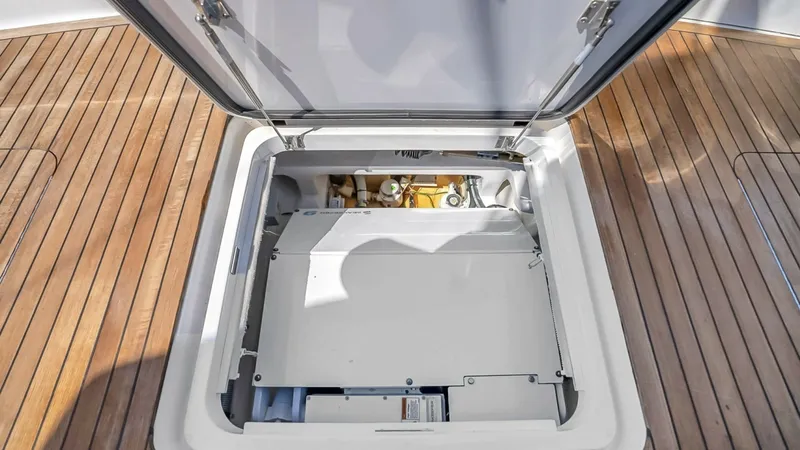 Slide: The Image of Engine Room Access Hatch This image showcases the engine room access hatch on the 2021 Viking 48 Convertible. The hatch is integrated seamlessly into the teak deck, providing easy access to the vessel's mechanical systems. The high-quality stainless steel hinges and secure latch - 7224889