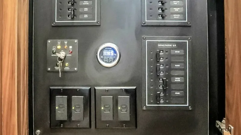 Slide: The Image of Electrical Control Panel Cabinet This image showcases the sophisticated electrical control panel of the 2021 Viking 48 Convertible. Encased in a sleek wooden cabinet, the panel offers easy access to all essential electrical systems with clearly labeled switches and controls. The design e - 7224865