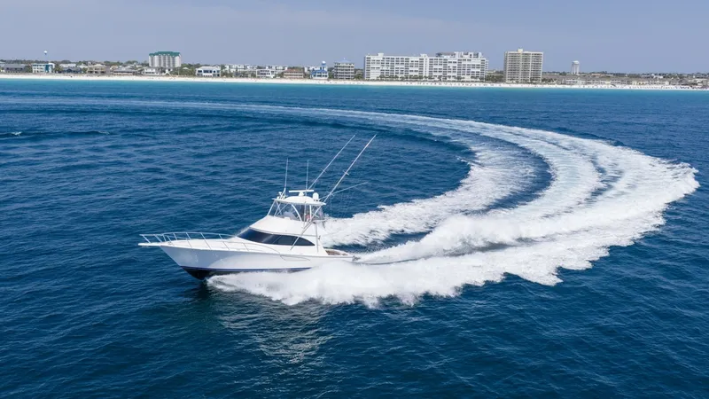 Slide: The Image of Viking 48 Convertible at Sea The 2021 Viking 48 Convertible cuts through the water with impressive agility, showcasing its sleek hull design and powerful performance. The vessel is captured making a dynamic turn, leaving a trail of white wake against the deep blue sea. Its flybridge - 7224921