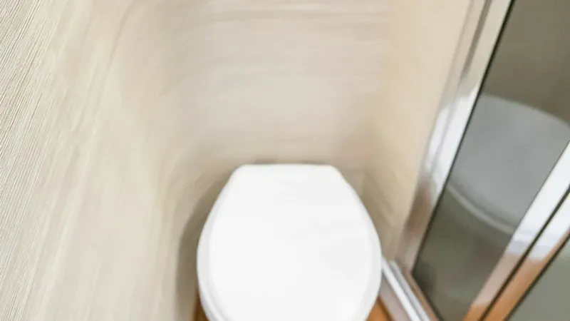 Slide: The Image of Compact Ensuite Bathroom This efficient ensuite bathroom on the Viking 48 Convertible features a sleek, modern design with high-quality finishes. The space-efficient layout includes a contemporary toilet and a glass-enclosed shower, offering functionality and style. The subtle wa - 7224878