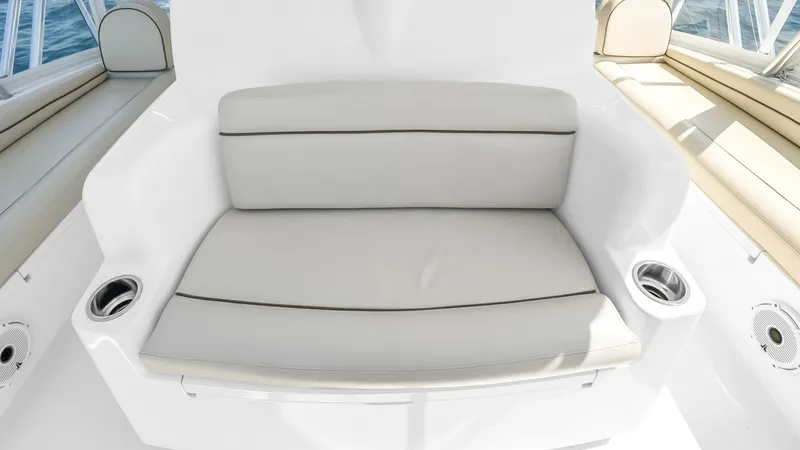 Slide: The Image of Flybridge Seating Area This well-appointed flybridge seating area on the 2021 Viking 48 Convertible offers plush, cushioned seating for comfort during voyages. The sleek, white finish and integrated cup holders enhance the functionality and style of the space. Perfectly positio - 7224903