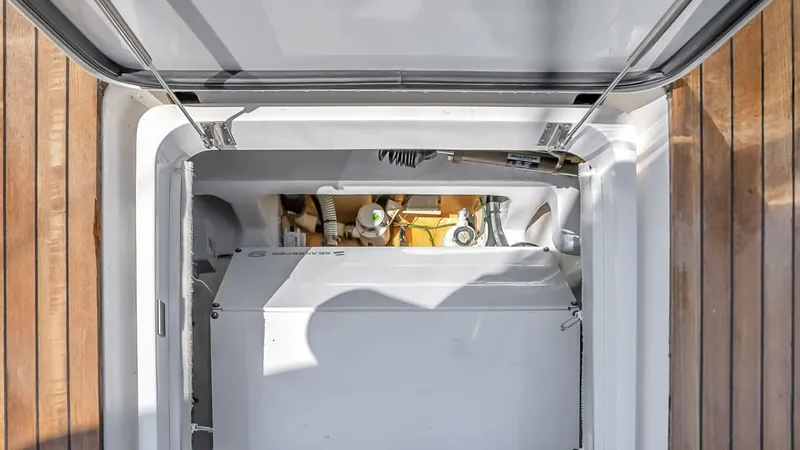 Slide: The Image of Engine Room Access Hatch This image showcases the engine room access hatch aboard the 2021 Viking 48 Convertible, 'High Impact'. The hatch is seamlessly integrated into the teak flooring, providing easy entry to the well-maintained engine compartment. This design ensures both fun - 7224888