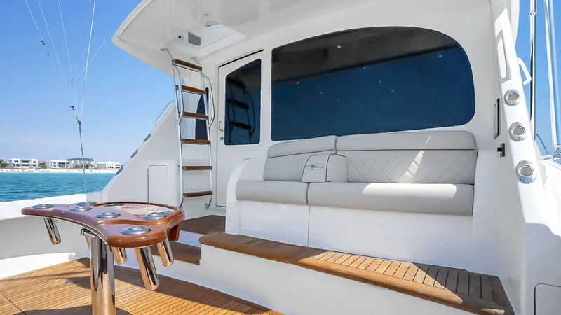 Slide: The Image of Spacious Cockpit with Seating The cockpit of the 2021 Viking 48 Convertible showcases elegant teak decking and a comfortable seating area, perfect for relaxation or entertaining. The built-in bench seating is complemented by a high-gloss release marine fighting chair, ideal for sportf - 7224885