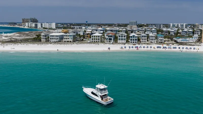 Slide: The Image of Aerial View of Viking 48 Convertible This stunning aerial shot captures the Viking 48 Convertible, 'High Impact', gracefully set against a picturesque beachfront. The vessel's sleek lines and spacious flybridge are prominent, showcasing its impressive design. The turquoise waters and coastal - 7224926