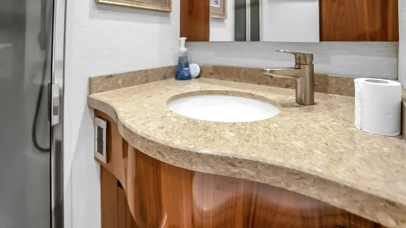 Slide: The Image of Luxurious Bathroom Vanity This elegant bathroom vanity on the 2021 Viking 48 Convertible features a beautifully crafted marble countertop paired with rich wood cabinetry. The modern faucet and ample counter space provide both functionality and style, enhancing the overall luxuriou - 7224873
