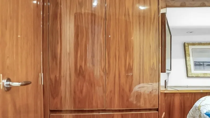 Slide: The Image of Stateroom Closet with Drawers This elegantly crafted stateroom closet features rich wood finishes, offering ample storage with three spacious drawers. The sleek design complements the sophisticated interior of the Viking 48 Convertible, enhancing both functionality and style. Soft lig - 7224871