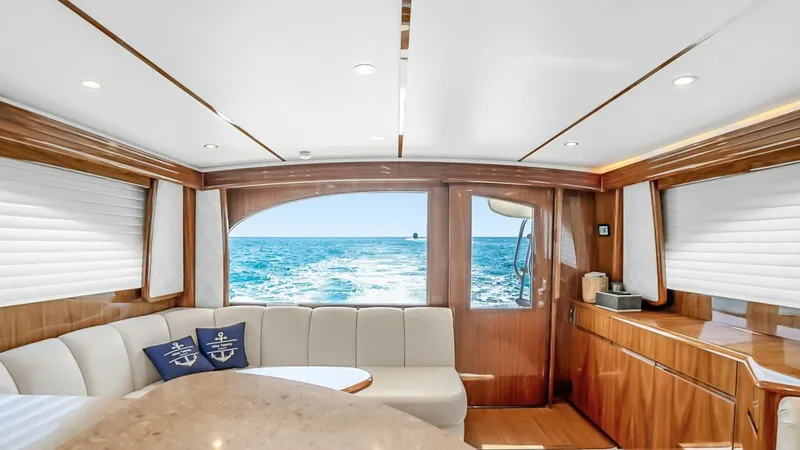 Slide: The Image of Salon with Ocean View This elegant salon on the 2021 Viking 48 Convertible offers a spacious and inviting atmosphere, enhanced by panoramic ocean views visible through large aft windows. The interior features plush seating, a polished wood finish, and modern lighting, creating - 7224853