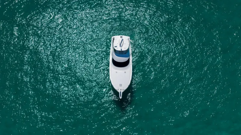 Slide: The Image of Aerial View of Bow This striking aerial shot captures the sleek bow of the 2021 Viking 48 Convertible, 'High Impact'. The vessel glides effortlessly through the vibrant turquoise waters, showcasing its elegant design and superior craftsmanship. The spacious foredeck is clea - 7224932