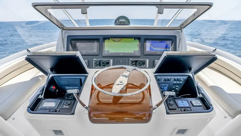 Slide: The Image of Flybridge Helm Station The flybridge helm station on the 2021 Viking 48 Convertible features a sleek, modern design with advanced navigation displays and ergonomic controls. The polished wood steering wheel complements the high-tech instrumentation, providing both functionality - 7224899