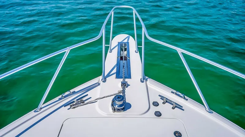 Slide: The Image of Bow Deck with Anchor System The bow deck of the 2021 Viking 48 Convertible showcases a sleek and functional anchor system, designed for effortless operation. The polished stainless steel hardware complements the pristine white finish, enhancing the vessel's modern aesthetic. Safety - 7224894