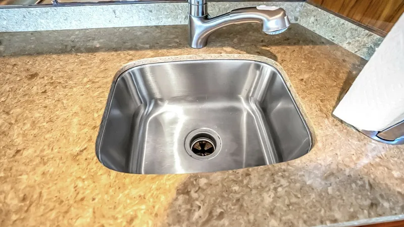 Slide: The Image of Galley Sink and Countertop This image showcases the stylish and functional galley sink of the 2021 Viking 48 Convertible. The stainless steel sink is set into a durable, high-quality countertop, offering both practicality and elegance. The modern faucet complements the sleek design - 7224861