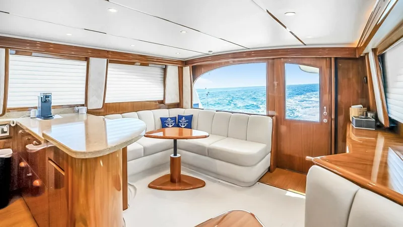 Slide: The Image of Spacious Salon with Ocean Views This inviting salon on the 2021 Viking 48 Convertible showcases elegant finishes with rich wood accents and plush seating. Large windows offer panoramic ocean views, flooding the space with natural light. The layout features a comfortable L-shaped sofa an - 7224856