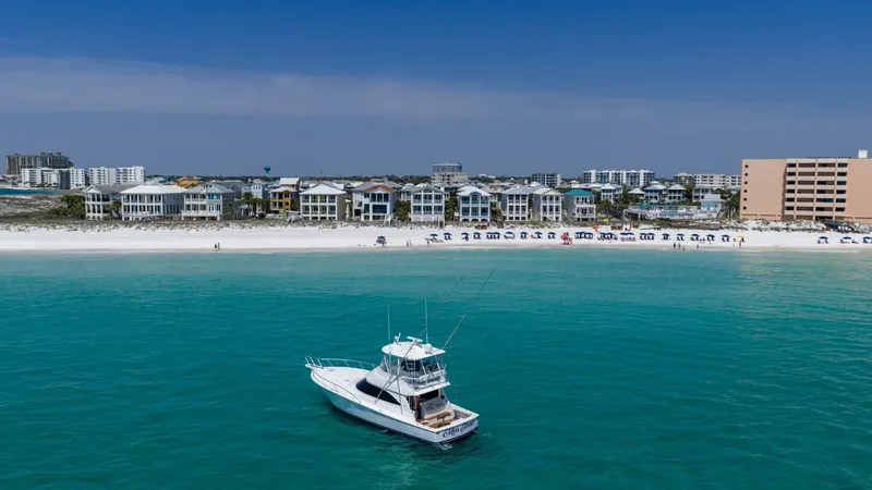 Slide: The Image of Aerial View of Viking 48 Convertible The 2021 Viking 48 Convertible, named High Impact, is showcased in a stunning aerial view against a backdrop of pristine shoreline. This elegant vessel boasts a sleek design, perfect for both fishing and cruising. Its spacious flybridge and open cockpit h - 7224927