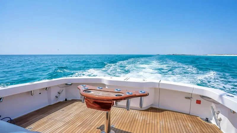 Slide: The Image of Spacious Aft Deck with Rod Holders The aft deck of the 2021 Viking 48 Convertible provides an expansive and well-equipped space for fishing enthusiasts. Featuring a robust teak finish, the deck is complemented by multiple rod holders and a central fighting chair, ensuring functionality and - 7224887