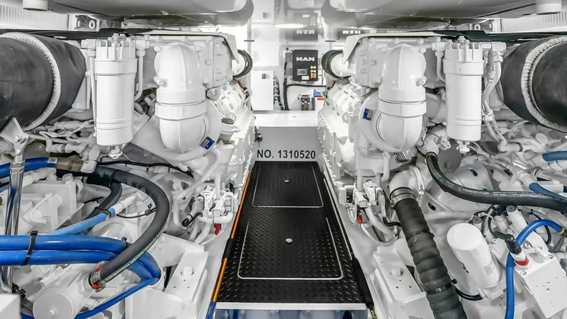 Slide: The Image of Engine Room with Dual MAN Engines This image showcases the engine room of the 2021 Viking 48 Convertible, housing dual MAN engines. The immaculate setup features organized piping and cabling, highlighting the vessel's advanced engineering and attention to detail. The bright, well-lit spac - 7224905